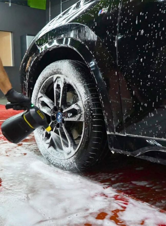 Car wash à Anderlecht : lavage d'une jante à la mousse active